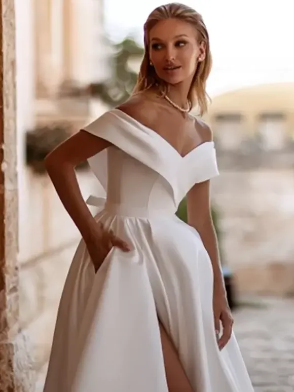 Robe de mariée vintage avec traîne épaules dénudées manches courtes fente sur le devant en satin.