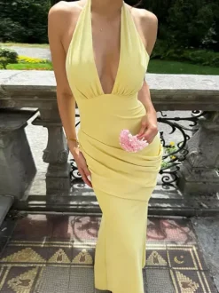 Robe de soirée jaune à col halter et décolleté plongeant style sirène dos lacé et taille froncée