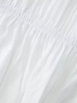 Robe de vacances fluide à volants et smocks épaules dénudées manches à volants idéale pour les vacances d'été.