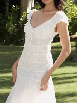 Robe de vacances fluide à volants et smocks épaules dénudées manches à volants idéale pour les vacances d'été.