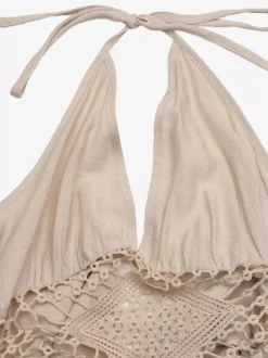 Robe longue beige à col halter pour femme ornée de découpes en crochet sans manches fluide idéale pour l'été et la plage.