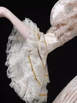 Robe longue de bal champagne style victorien rococo ornée de dentelle manches évasées et imprimé floral.
