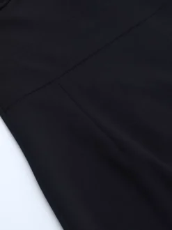 Robe longue noire élégante dos nu à lacets sans manches et décolleté licou idéale pour une soirée en amoureux.
