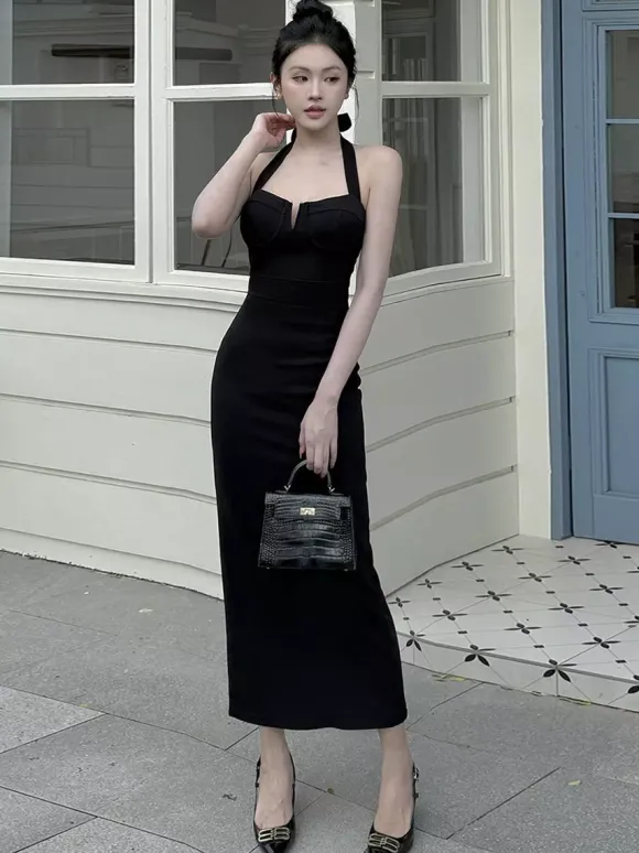 Robe longue noire élégante dos nu à lacets sans manches et décolleté licou idéale pour une soirée en amoureux.