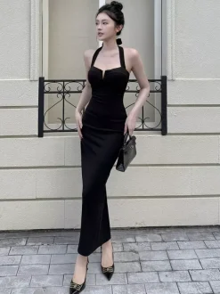 Robe longue noire élégante dos nu à lacets sans manches et décolleté licou idéale pour une soirée en amoureux.