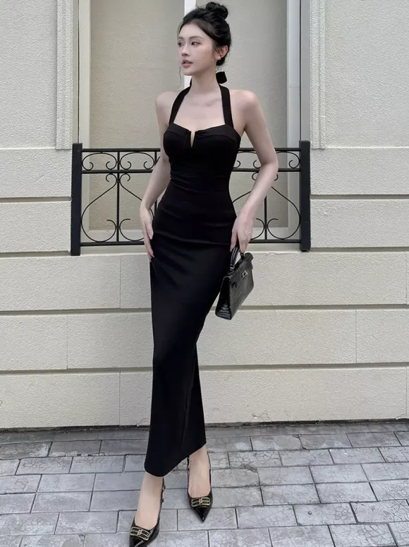 Robe longue noire élégante dos nu à lacets sans manches et décolleté licou idéale pour une soirée en amoureux.
