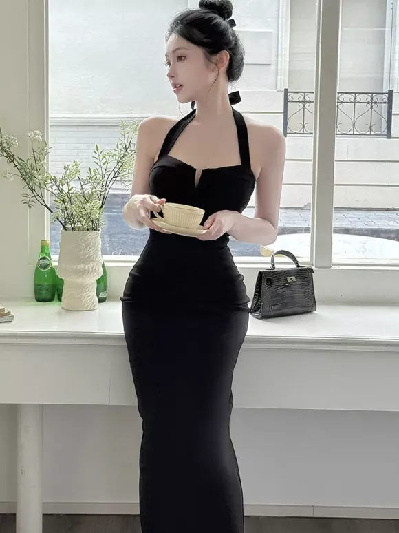 Robe longue noire élégante dos nu à lacets sans manches et décolleté licou idéale pour une soirée en amoureux.