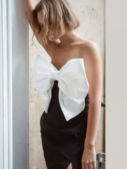 Robe noire chic à bretelles dos nu et sans manches ornée de n艙uds idéale pour une soirée romantique.