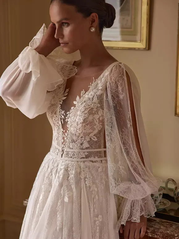 Robe de mariée bohème en mousseline et dentelle coupe trapèze avec traîne taille naturelle fermeture éclair manches longues col en V blanche