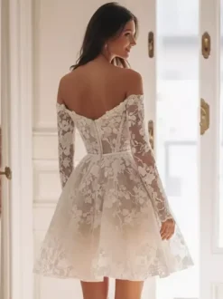 Robe de mariée courte en tulle décolleté en c艙ur manches 3/4 taille naturelle.