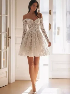 Robe de mariée courte en tulle décolleté en c艙ur manches 3/4 taille naturelle.