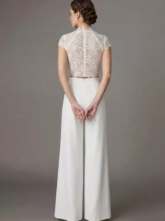 Robe de mariée deux pièces en crêpe stretch décolleté travaillé longueur au sol fermeture éclair manches courtes.