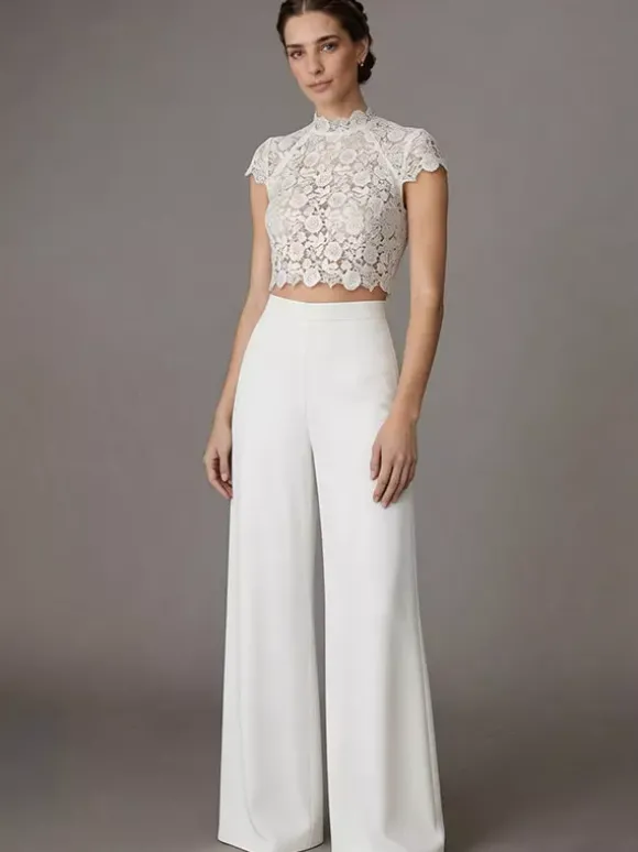 Robe de mariée deux pièces en crêpe stretch décolleté travaillé longueur au sol fermeture éclair manches courtes.