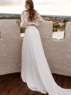 Robe de mariée deux pièces en mousseline de soie et dentelle col bijou avec traîne boutons fonctionnels manches longues longueur 40 cm ivoire