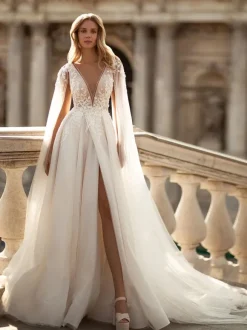 Robe de mariée en dentelle col V boutonné sur dos pélerine amovible jupe fendue au sol