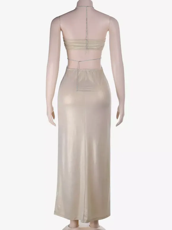 Robe de soirée abricot en satin sirène moulante à strass dos nu fente latérale et décolleté dos nu ornée de strass.