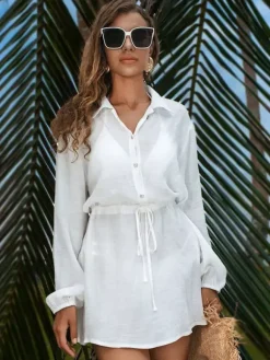 Robe de vacances blanche chic à boutons cintrants manches longues et col rabattu.