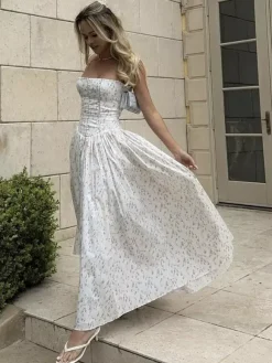 Robe longue bustier à bretelles spaghetti et imprimé floral discret style trapèze idéale pour une soirée romantique.