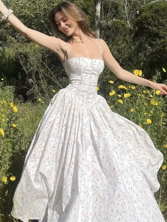 Robe longue bustier à bretelles spaghetti et imprimé floral discret style trapèze idéale pour une soirée romantique.