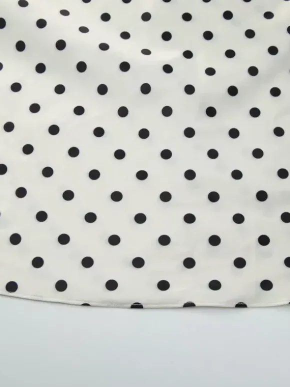 Robe longue crème flatteuse à col en V et pois noirs idéale pour les soirées.