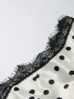 Robe longue crème flatteuse à col en V et pois noirs idéale pour les soirées.