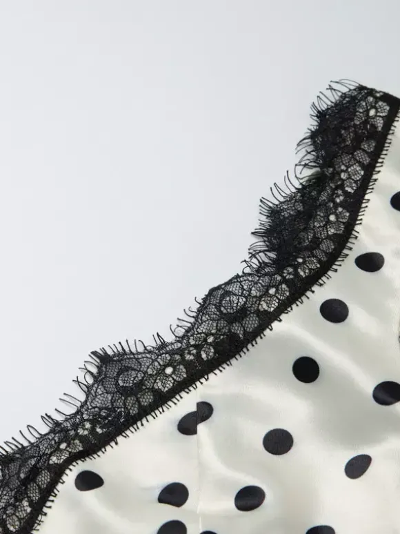 Robe longue crème flatteuse à col en V et pois noirs idéale pour les soirées.