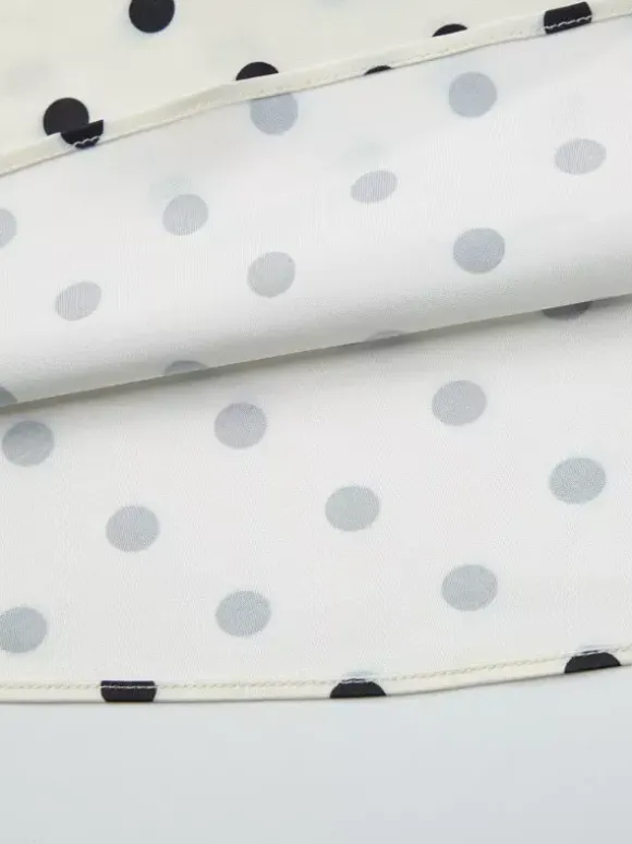 Robe longue crème flatteuse à col en V et pois noirs idéale pour les soirées.