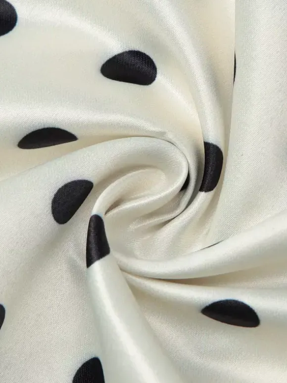 Robe longue crème flatteuse à col en V et pois noirs idéale pour les soirées.