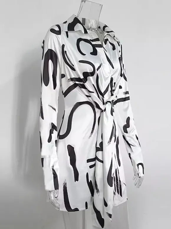 Robe noire élégante à manches longues et coupe asymétrique idéale pour tous les jours.