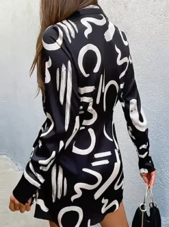 Robe noire élégante à manches longues et coupe asymétrique idéale pour tous les jours.