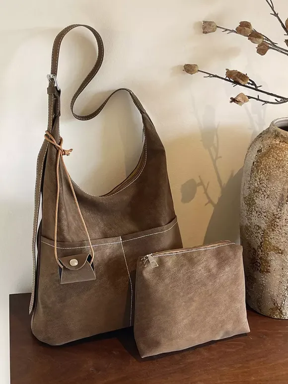 Sac hobo vintage en daim avec surpiqûres contrastées bandoulière ajustable et porte-monnaie intégré.