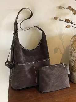 Sac hobo vintage en daim avec surpiqûres contrastées bandoulière ajustable et porte-monnaie intégré.