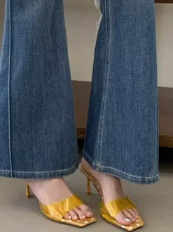 Sandales jaunes à talons hauts transparentes à bout ouvert et sans talon.