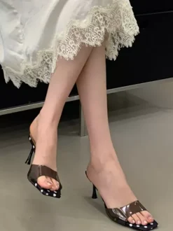 Sandales jaunes à talons hauts transparentes à bout ouvert et sans talon.
