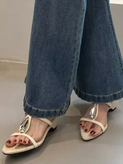 Sandales noires à talons compensés en forme de T ornées de strass.