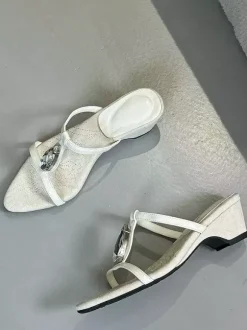 Sandales noires à talons compensés en forme de T ornées de strass.