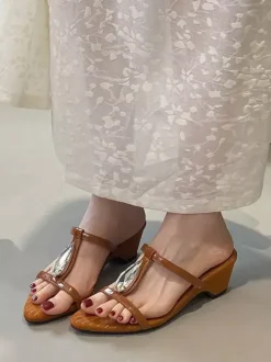 Sandales noires à talons compensés en forme de T ornées de strass.