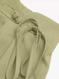 Short plissé taille haute pour femme asymétrique à nouer à la taille coupe ample et décontractée idéal pour l'été.