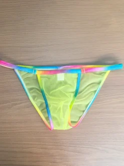 String pour homme avec ceinture arc-en-ciel en maille transparente. Sous-vêtement string en maille transparente.