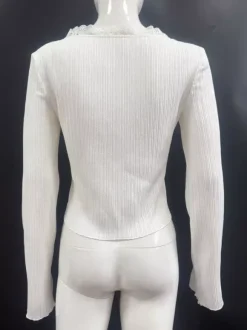 Top en maille côtelée à col en V et manches cloche orné de dentelle collection femme 2026