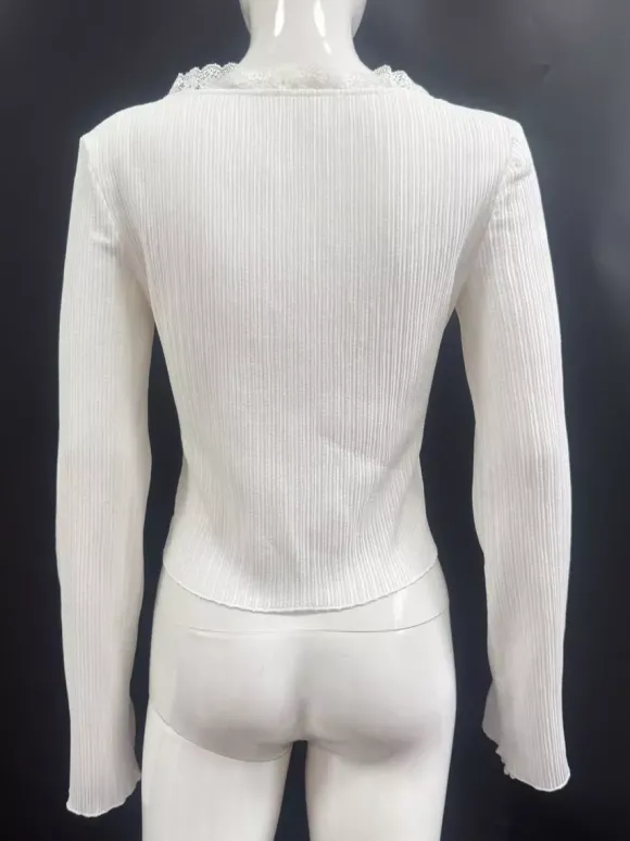 Top en maille côtelée à col en V et manches cloche orné de dentelle collection femme 2026