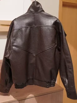 Veste bomber vintage en similicuir noir et marron uni coupe décontractée taille élastiquée.